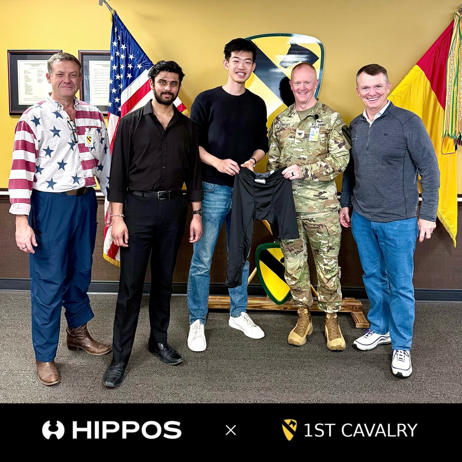 Hippos and 1st Cavalry Division representatives at Fort Cavazos, holding the Hippos soft exoskeleton.